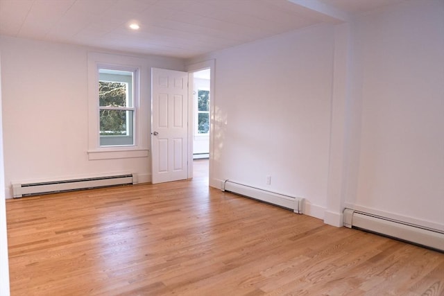 unfurnished room featuring light wood-type flooring and baseboard heating