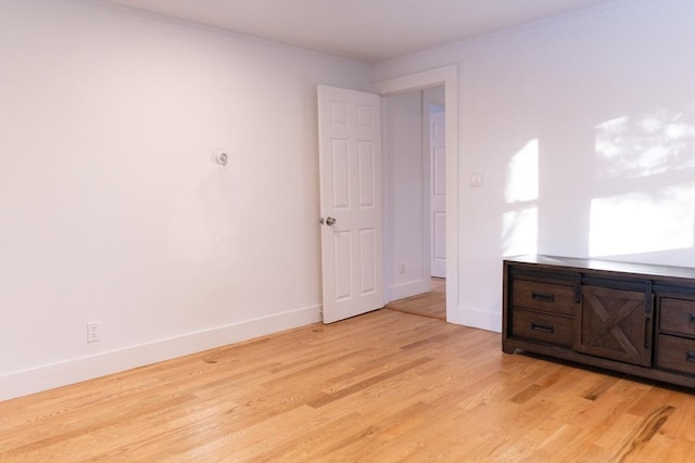 unfurnished bedroom featuring ornamental molding and light hardwood / wood-style floors