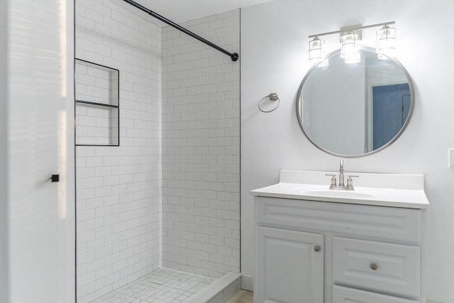 bathroom with vanity and a tile shower