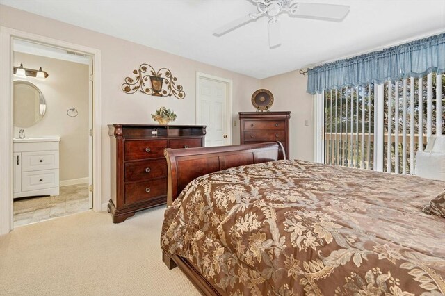 carpeted bedroom with a sink, ceiling fan, ensuite bathroom, baseboards, and access to outside