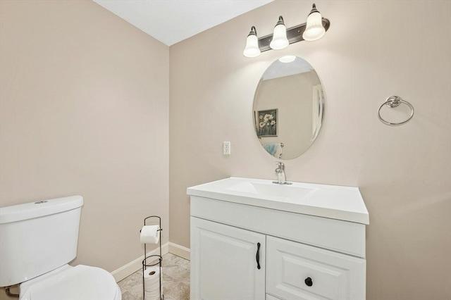 half bath with vanity, toilet, and baseboards