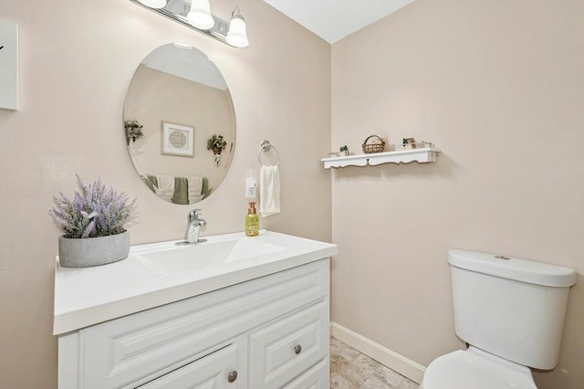 half bath with toilet, vanity, and baseboards