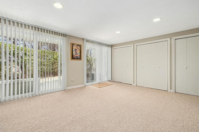 unfurnished bedroom with recessed lighting, access to exterior, two closets, and carpet floors