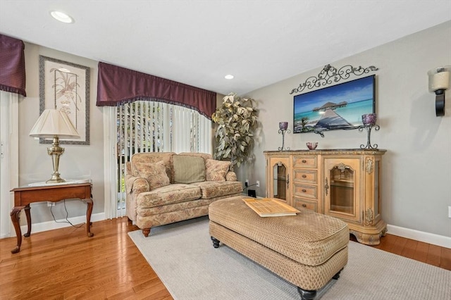 living room featuring baseboards, recessed lighting, and wood finished floors