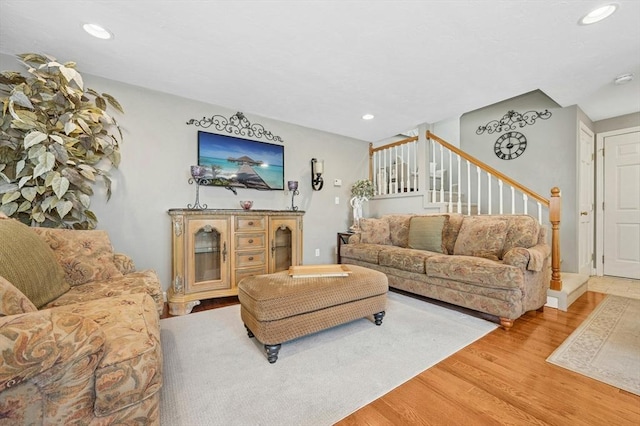 living area with light wood finished floors, recessed lighting, and stairway