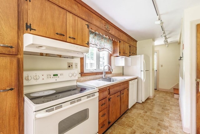 405 Granby Rd, South Hadley, MA 01075 - kitchen with white appliances, a sink, under cabinet range hood, brown cabinets, and light countertops