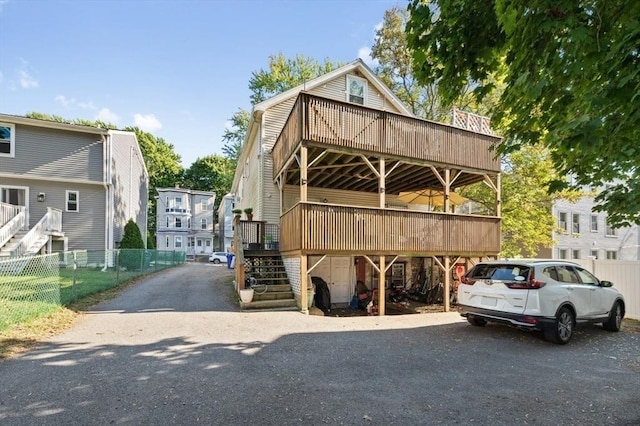 view of parking with stairs and fence