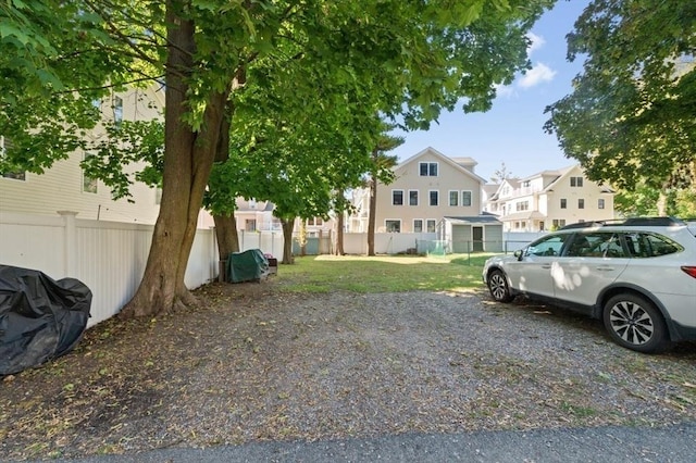 view of parking featuring a residential view and fence