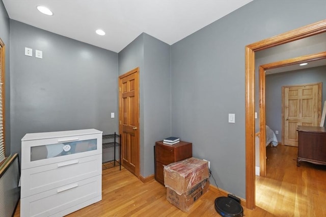 corridor featuring recessed lighting, light wood-type flooring, and baseboards