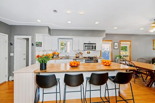 kitchen featuring white cabinets, light wood finished floors, and appliances with stainless steel finishes