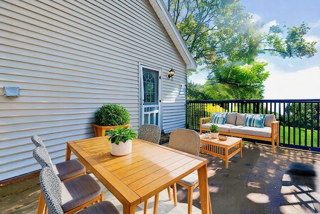 wooden terrace with outdoor dining space and outdoor lounge area