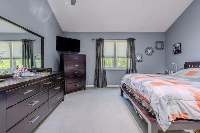 bedroom featuring lofted ceiling, light colored carpet, baseboards, and a ceiling fan