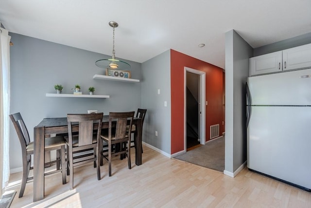 dining area featuring light wood-type flooring and baseboards