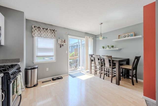 dining space featuring wood finished floors and baseboards