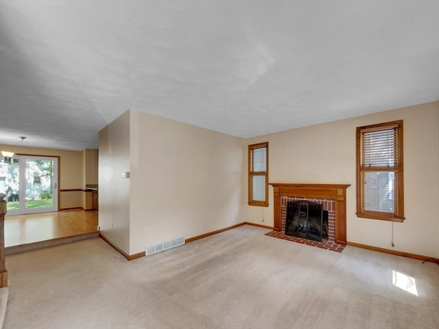 unfurnished living room featuring light carpet and a fireplace