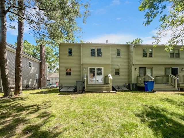 rear view of house featuring a yard and central air condition unit