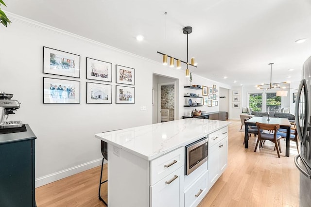 172 Orchard St Unit 172, Watertown, MA 02472 - kitchen featuring stainless steel appliances, open floor plan, white cabinetry, crown molding, and a center island