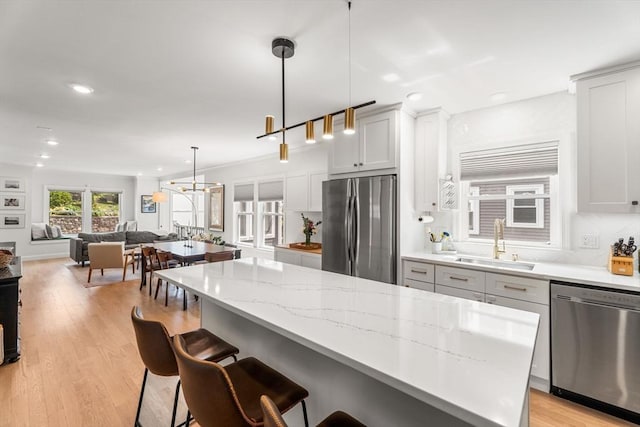 172 Orchard St Unit 172, Watertown, MA 02472 - kitchen with stainless steel appliances, a sink, a kitchen breakfast bar, recessed lighting, and light stone counters