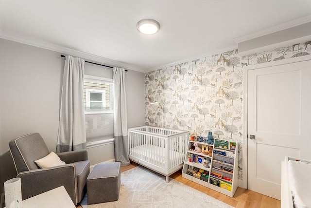 172 Orchard St Unit 172, Watertown, MA 02472 - bedroom with crown molding, wood finished floors, a crib, and wallpapered walls