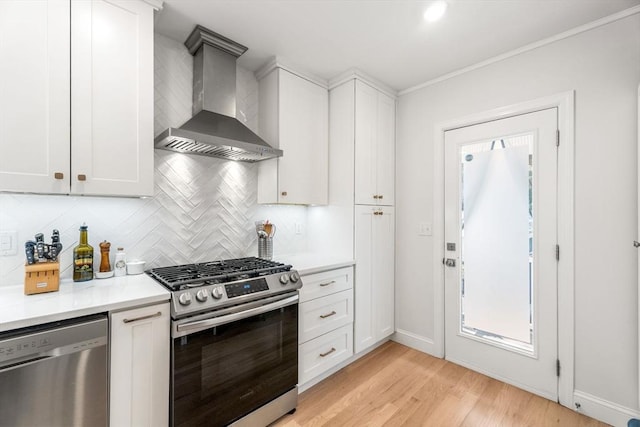 172 Orchard St Unit 172, Watertown, MA 02472 - kitchen featuring stainless steel appliances, wall chimney exhaust hood, light wood-style floors, decorative backsplash, and light countertops