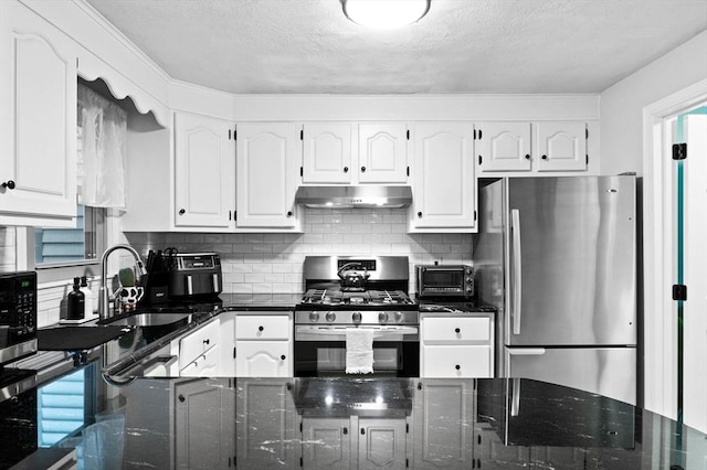 119 Wellman Ave Unit 119, Chelmsford, MA 01863 - kitchen with stainless steel appliances, a sink, under cabinet range hood, dark stone countertops, and a textured ceiling