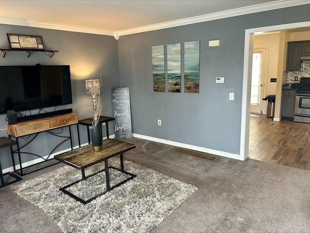 interior space featuring baseboards, ornamental molding, and dark carpet