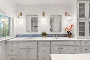 bathroom with ornamental molding and double vanity