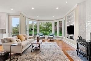 living area featuring crown molding, a wood stove, wood finished floors, and recessed lighting