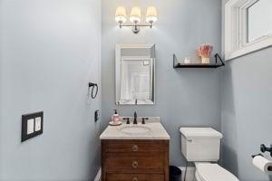 half bathroom featuring toilet and vanity