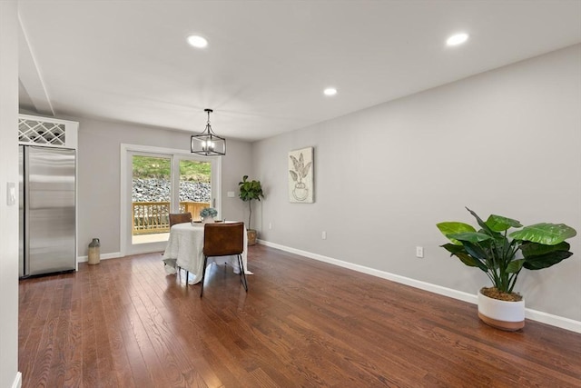 dining area with a chandelier, baseboards, and dark wood finished floors