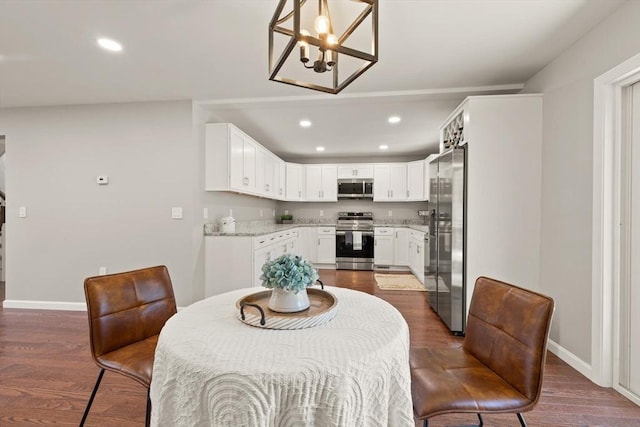 dining area with recessed lighting, baseboards, an inviting chandelier, and dark wood-style floors