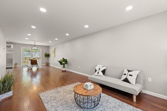 living room featuring baseboards, hardwood / wood-style flooring, recessed lighting, and a chandelier