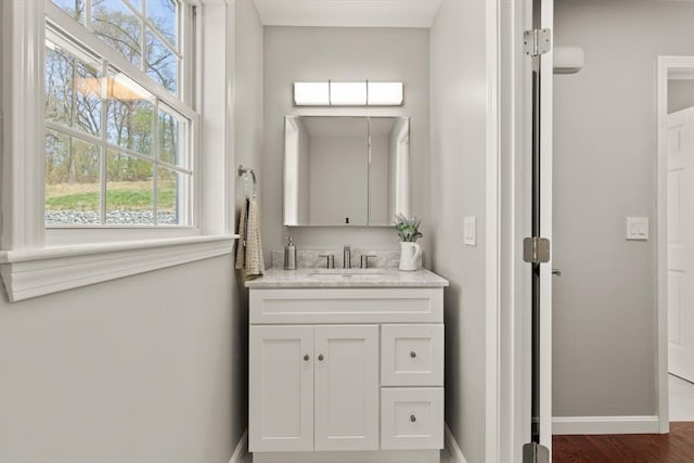 bathroom featuring baseboards, wood finished floors, and vanity