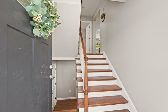 stairway with baseboards and wood finished floors