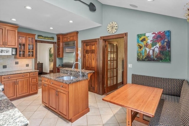 100 Williams Ave, Boston, MA 02136 - kitchen with stainless steel built in fridge, brown cabinetry, vaulted ceiling, tasteful backsplash, and glass insert cabinets