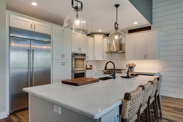 kitchen with light countertops, stainless steel appliances, white cabinetry, and dark wood-type flooring