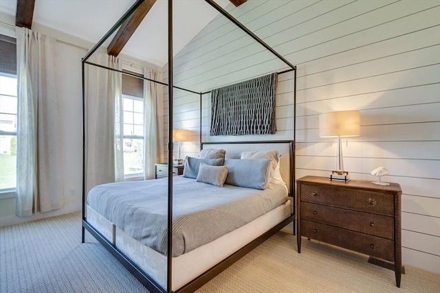 bedroom featuring carpet floors, wood walls, multiple windows, and vaulted ceiling with beams