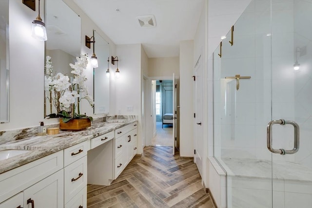 full bathroom featuring double vanity, a shower stall, and a sink