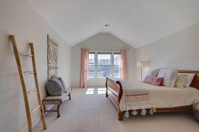 bedroom featuring light colored carpet, vaulted ceiling, and visible vents
