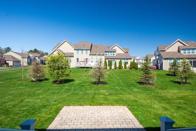 back of house featuring a residential view, a lawn, and a patio area