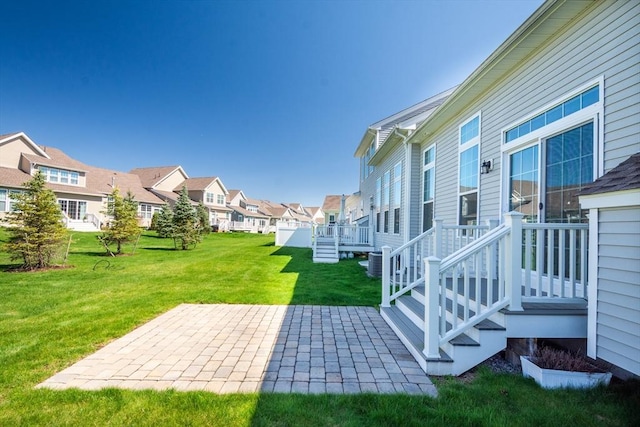 view of yard with a patio, a residential view, and central AC unit