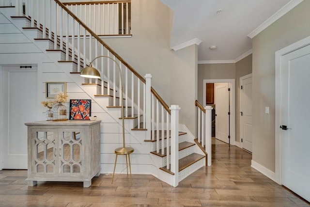 stairs with baseboards, ornamental molding, and wood finished floors