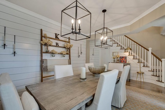 dining room with stairway, an inviting chandelier, wood finished floors, and crown molding