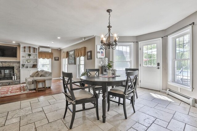 dining area with a wall mounted air conditioner, a chandelier, a baseboard radiator, recessed lighting, and a fireplace