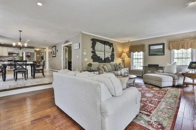living area featuring a chandelier, baseboard heating, dark wood-type flooring, and recessed lighting