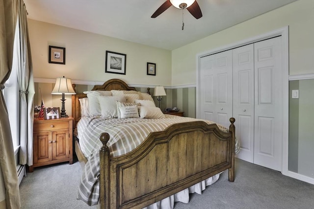 bedroom with carpet flooring, a closet, ceiling fan, and a baseboard radiator