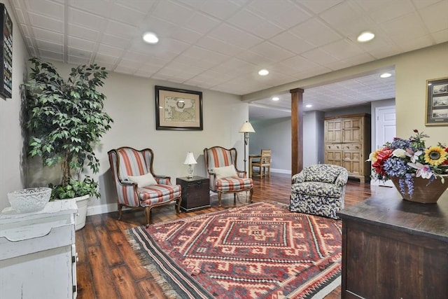 sitting room with baseboards, dark wood-style floors, recessed lighting, and decorative columns