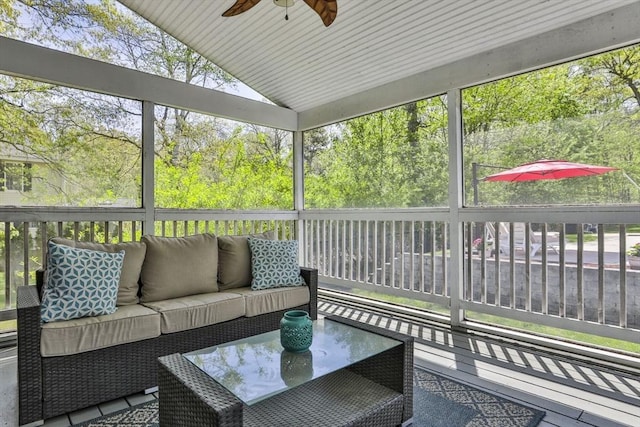 sunroom / solarium featuring ceiling fan, an outdoor living space, and vaulted ceiling
