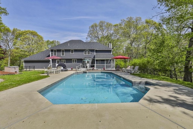 view of swimming pool with a sunroom, a patio, and fence