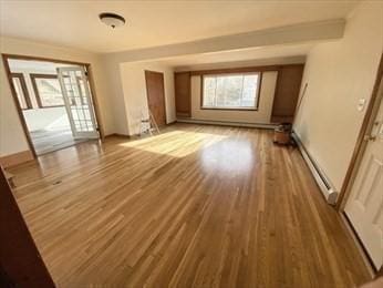 unfurnished living room with light hardwood / wood-style flooring and a baseboard radiator